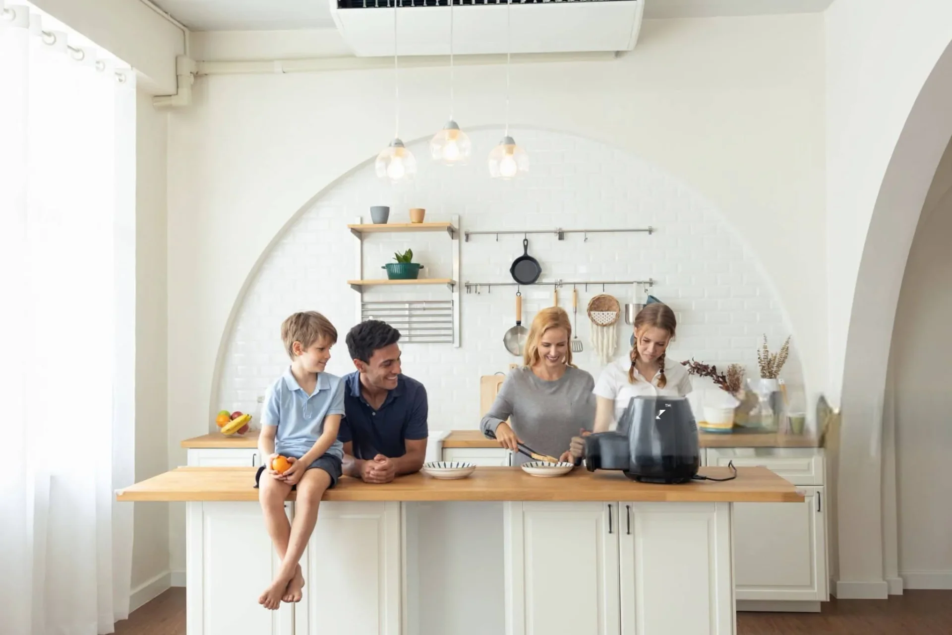Family in kitchen with smart gas leak alarm on wall for home safety
