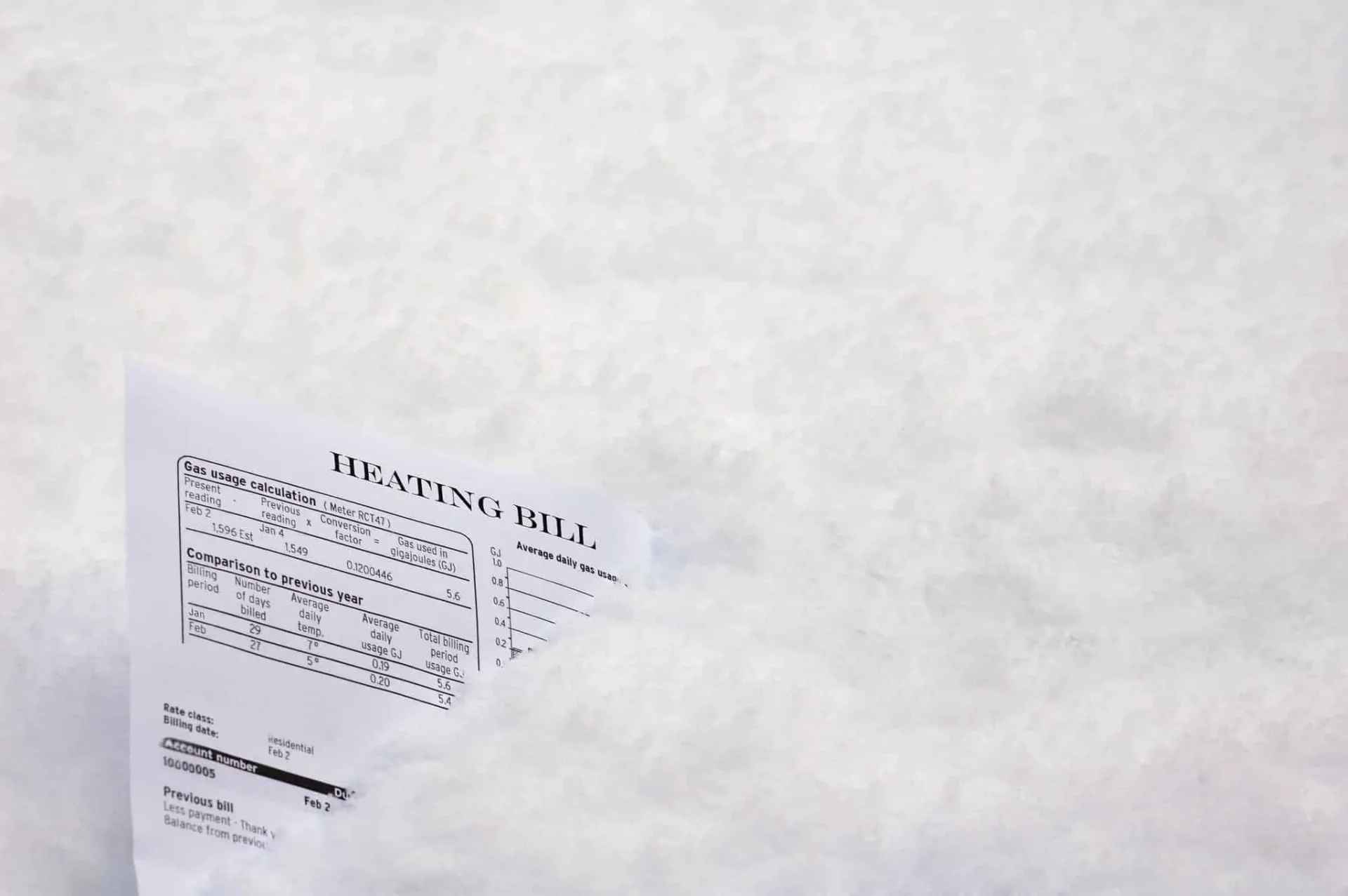 Heating bill stuck in the snow symbolizing high winter electricity costs