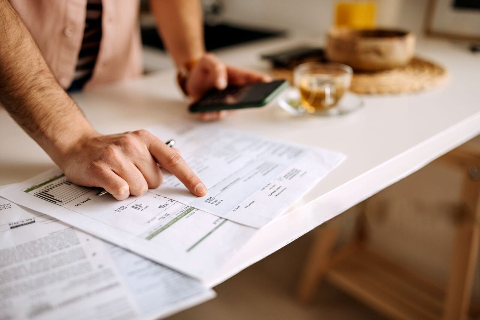 My Electric Bill Doubled in One Month: What Could Be Going On? 3 Shocked person at kitchen table holding utility bill showing my electric bill doubled in one month 1 -