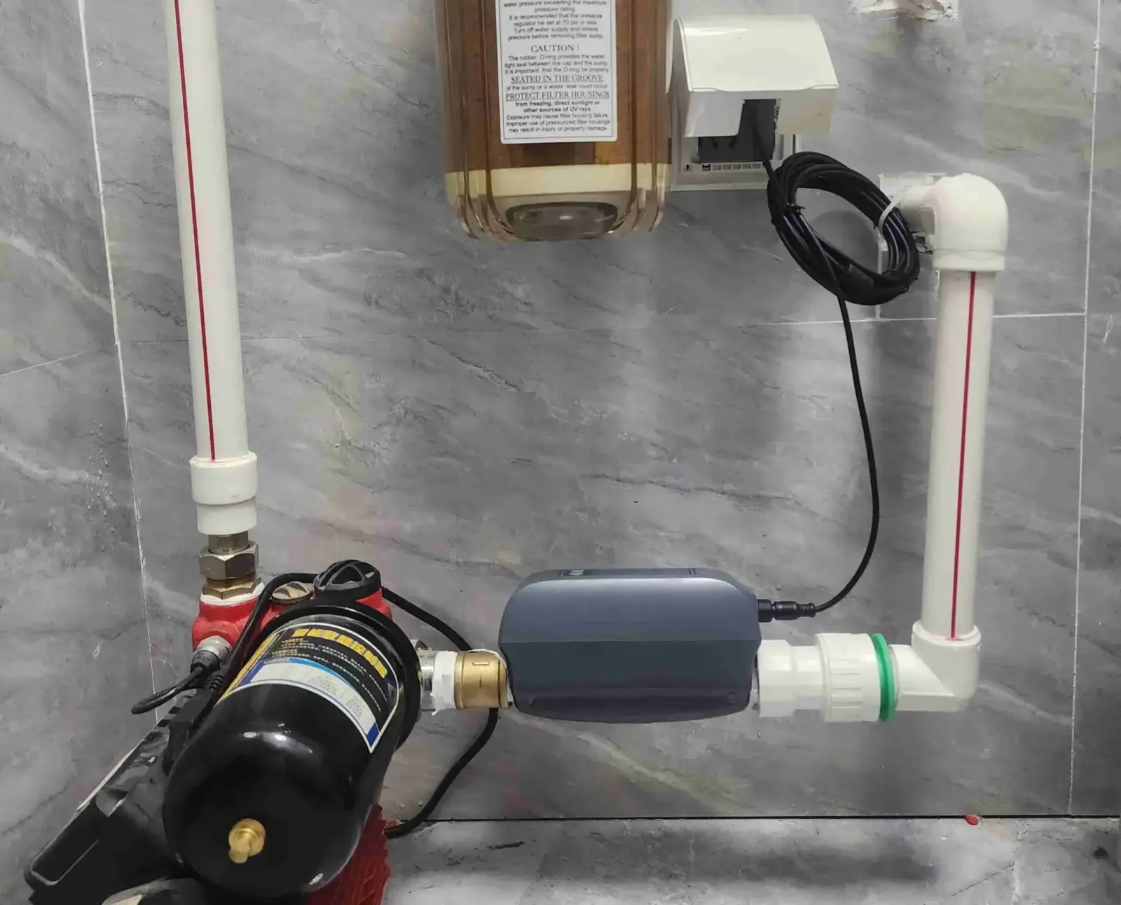 A clean bright North American home interior showing a main water shutoff valve with a smart automatic valve installed on the pipe by insurance requirement -