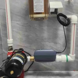A clean, bright North American home interior showing a main water shutoff valve with a smart automatic valve installed on the pipe by insurance requirement.