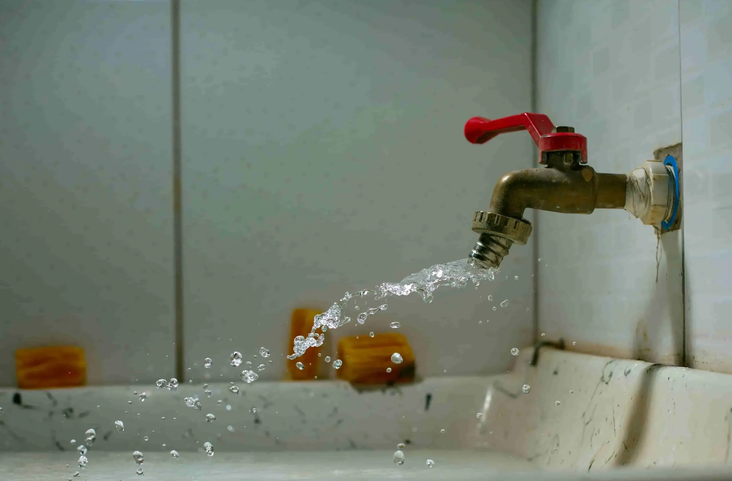Leaking faucet spraying water — a common household leak scenario that smart water shutoff valves can automatically prevent in 2025 {{brizy_dc_image_alt entityId=