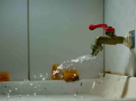 Leaking faucet spraying water — a common household leak scenario that smart water shutoff valves can automatically prevent in 2025