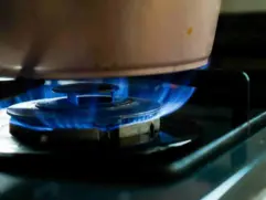 home natural gas detector：Gas stove burner on with pot, potential kitchen gas leak risk